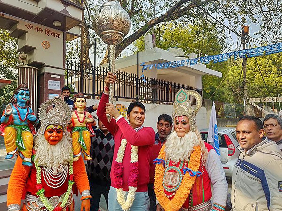 AAP candidate from Greater Kailash constituency Saurabh Bhardwaj holds a mace as he along with his supporters, dressed as Lord Hanuman, celebrates his victory in the Assembly polls, outside a temple in New Delhi, Tuesday, Feb. 11, 2020. (PTI Photo)