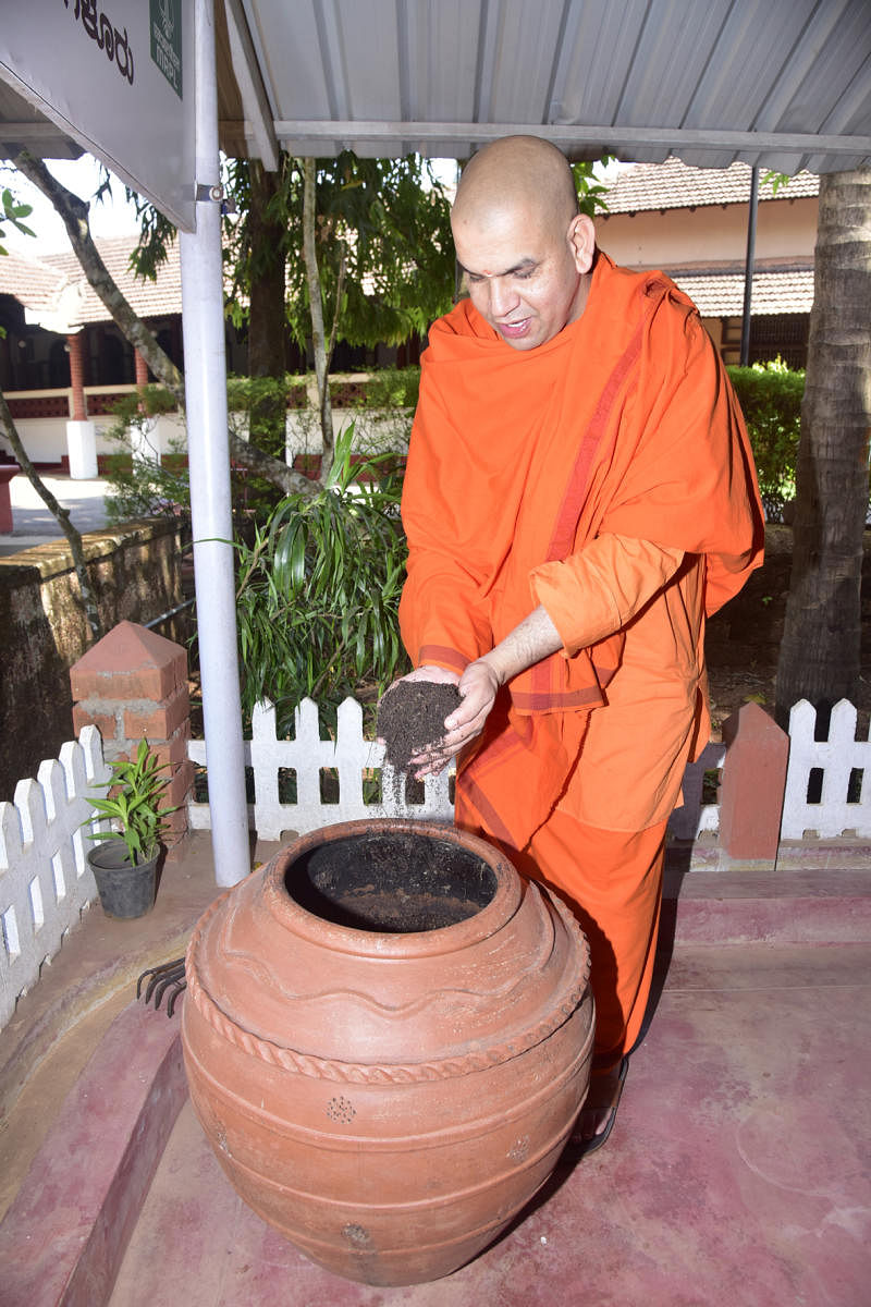 Swami Ekagamyananda, convener of Swaccha Mangaluru campaign of Ramakrishna Mission, shows manure prepared using pot-composting at Ramakrishna Mutt in Mangaladevi on Tuesday. DH Photo   