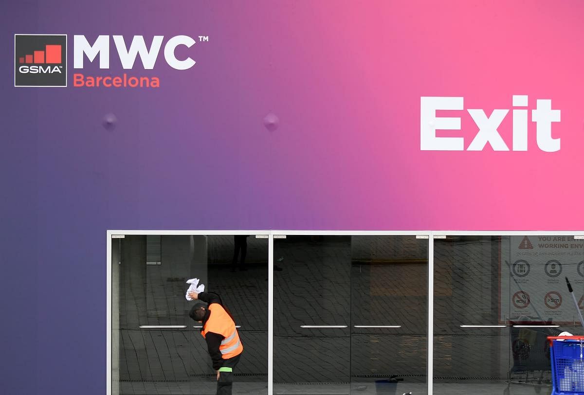 A worker cleans glass doors at the Mobile World Congress MWC venue on February 12, 2020 at the Fira Barcelona Montjuic centre in Barcelona. - Organisers of the World Mobile Congress said on February 12, 2020 that the world's top mobile trade fair would be