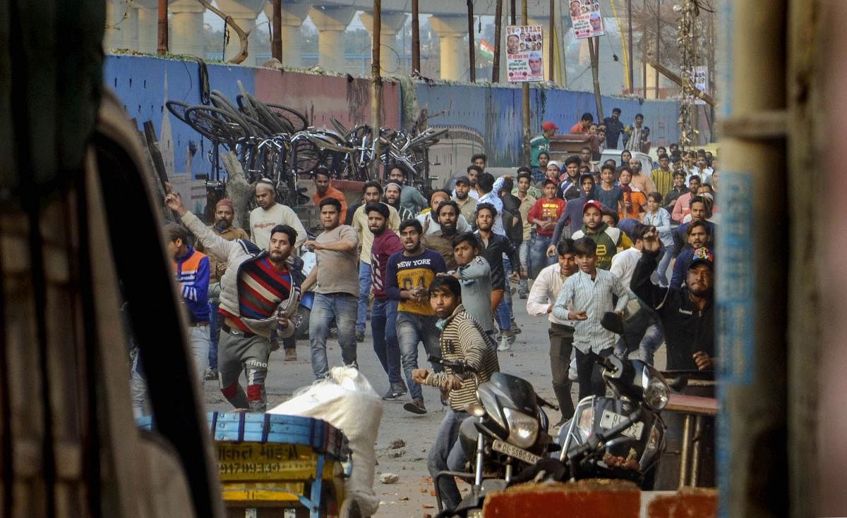 Protestors hurl stones after clashes broke out between pro and anti-CAA groups at Maujpur area, in East Delhi, Sunday, Feb. 23, 2020. (PTI Photo)