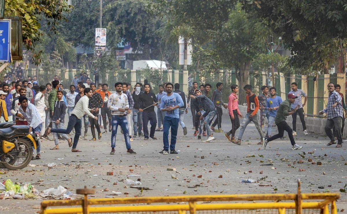 Protestors hurl stones after clashes broke out between pro and anti-CAA groups at Maujpur area, in north-east Delhi, Sunday, Feb. 23, 2020. (PTI Photo)