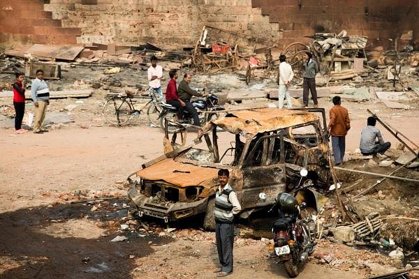Residents look at burnt-out vehicles following sectarian riots over India's new citizenship law, at Shiv Vihar area in New Delhi on February 28, 2020. (AFP Photo)