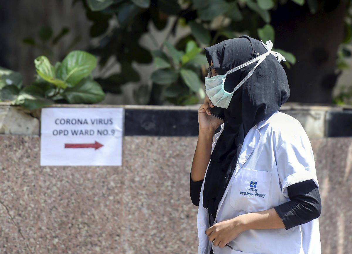 A medic wearing a facemask talks on her phone in the premises of Kasturba Hospital, where a special ward is set up for providing treatment to novel coronavirus patients, in Mumbai, Thursday, March 5, 2020. (PTI Photo)