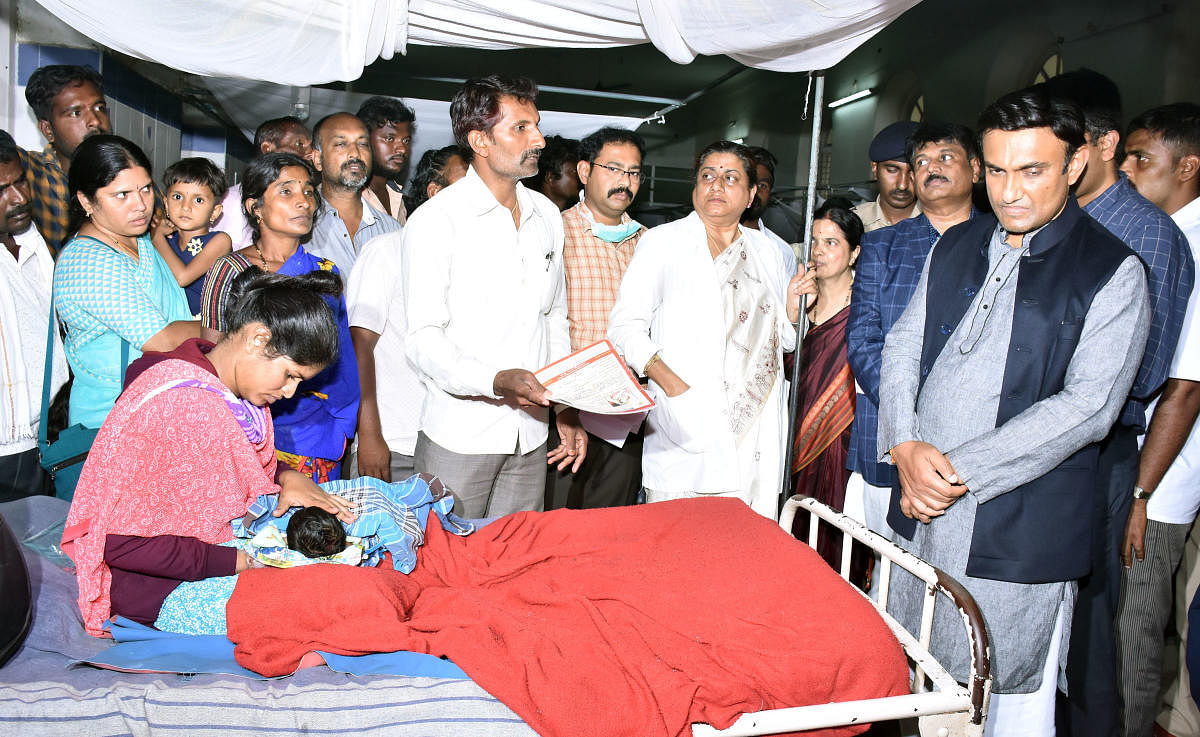 Medical Education Minister Dr K Sudhakar inquires health of a mother and the child at Cheluvamba Hospital, in Mysuru, on Saturday. (DH Photo)