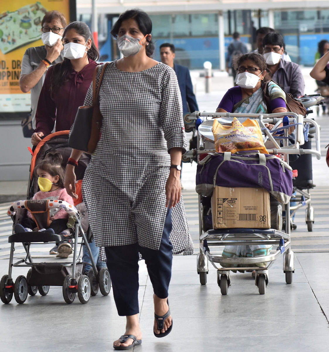 Passengers using masks due to the scare of coronavirus at the Kempegowda International Airport in Bengaluru. (DH Photo)