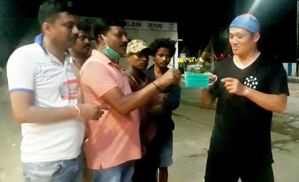 Local residents hand over a wear to the Chinese traveller in Kottigehara in Chikkamagaluru on Wednesday night.