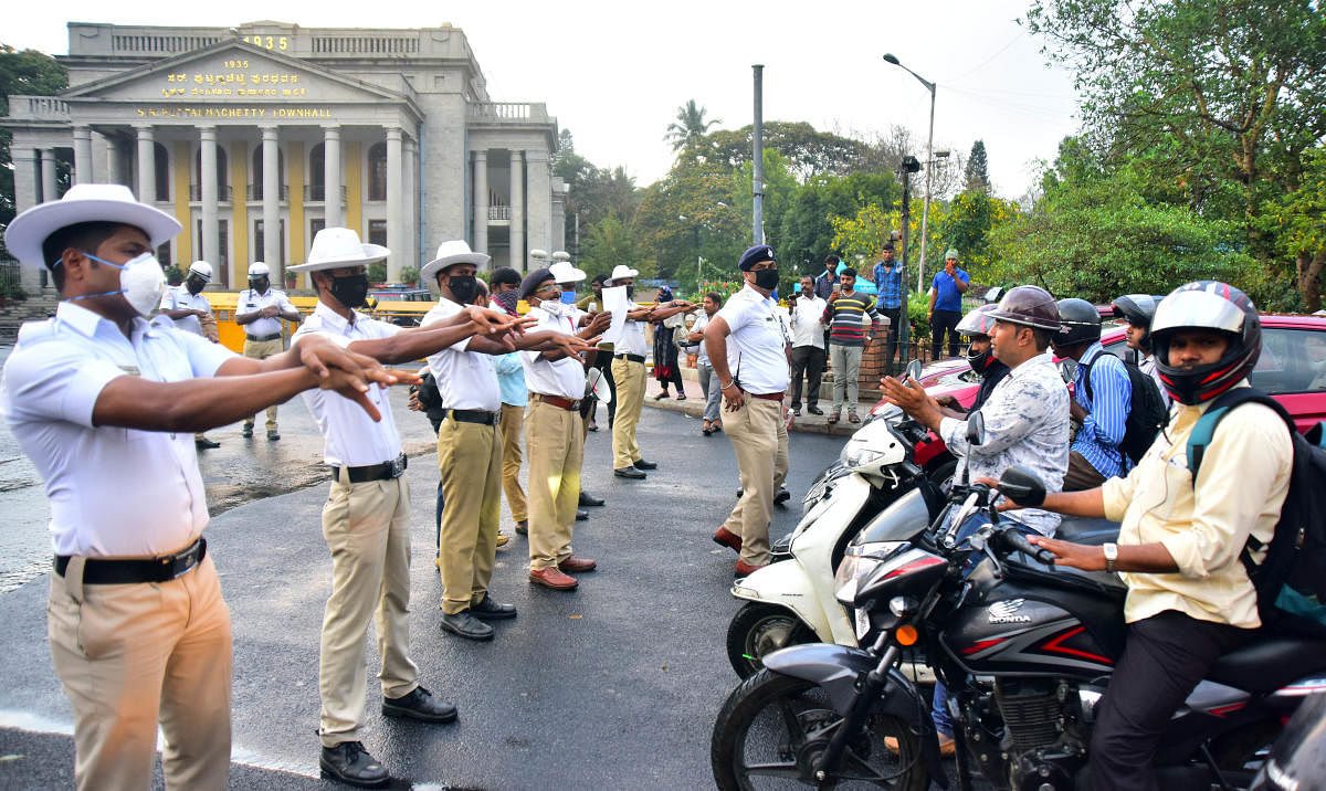 Traffic policemen demonstrate the correct way of washing hands at the Town Hall signal on Friday. DH PHOTO/ANUP RAGH T