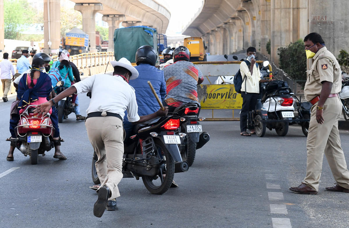 A traffic policeman canes a motorcyclist at T Dasarahalli on Tuesday. (R) This is how a cop caught hold of a man who stepped out on Mysuru Road. DH PhotoS/ B H Shivakumar AND ANUP RAGH T