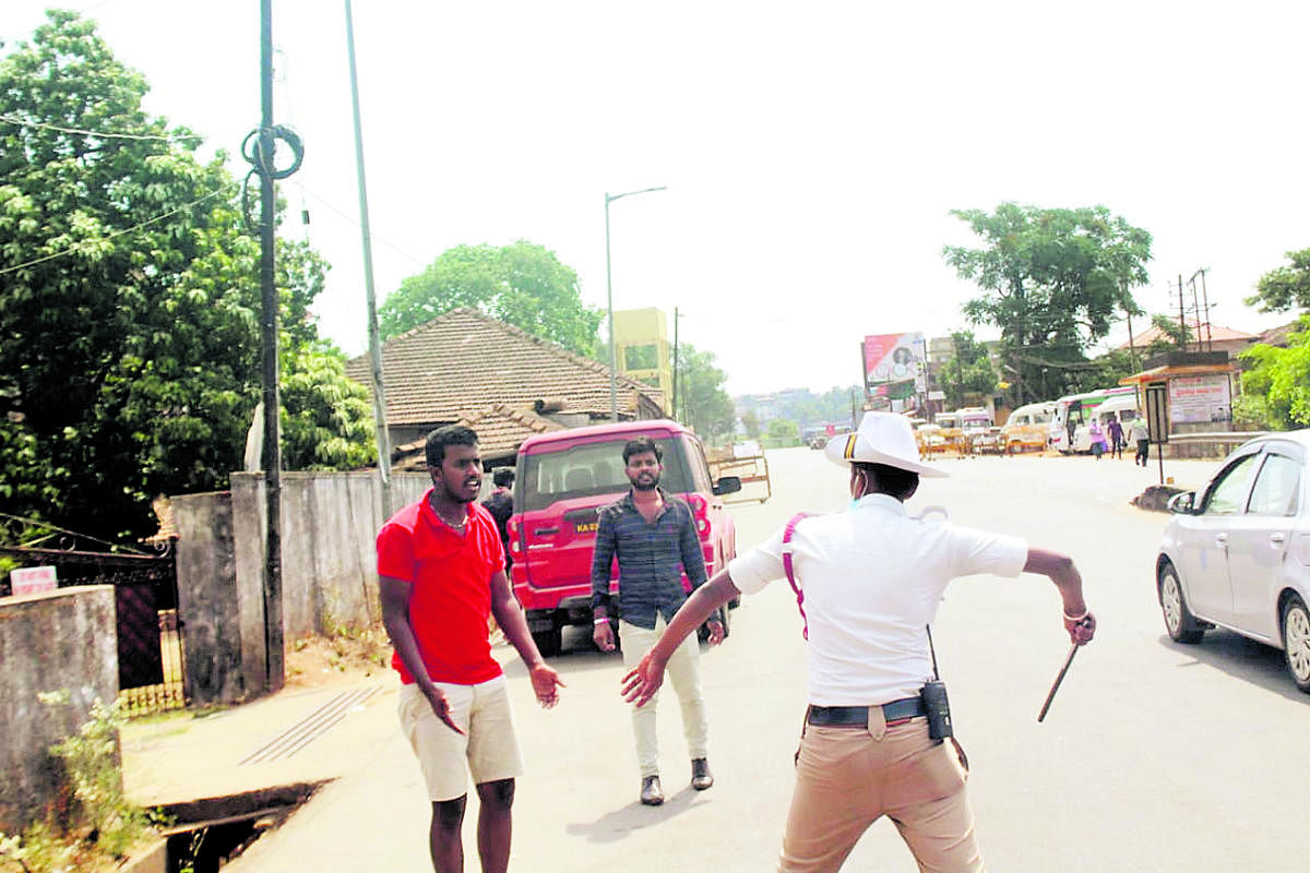 A policeman canes youth who violated the prohibitory orders. 
