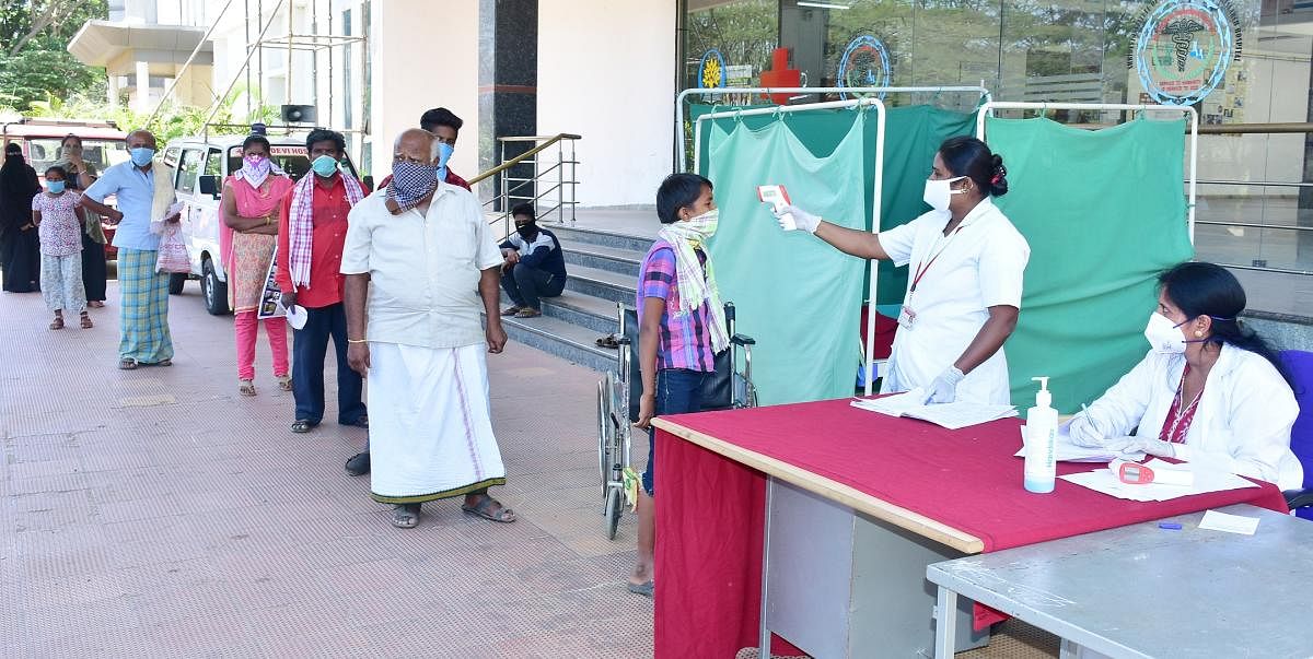 People undergo thermal screening at the Sridevi Hospital in Tumakuru. DH Photo.