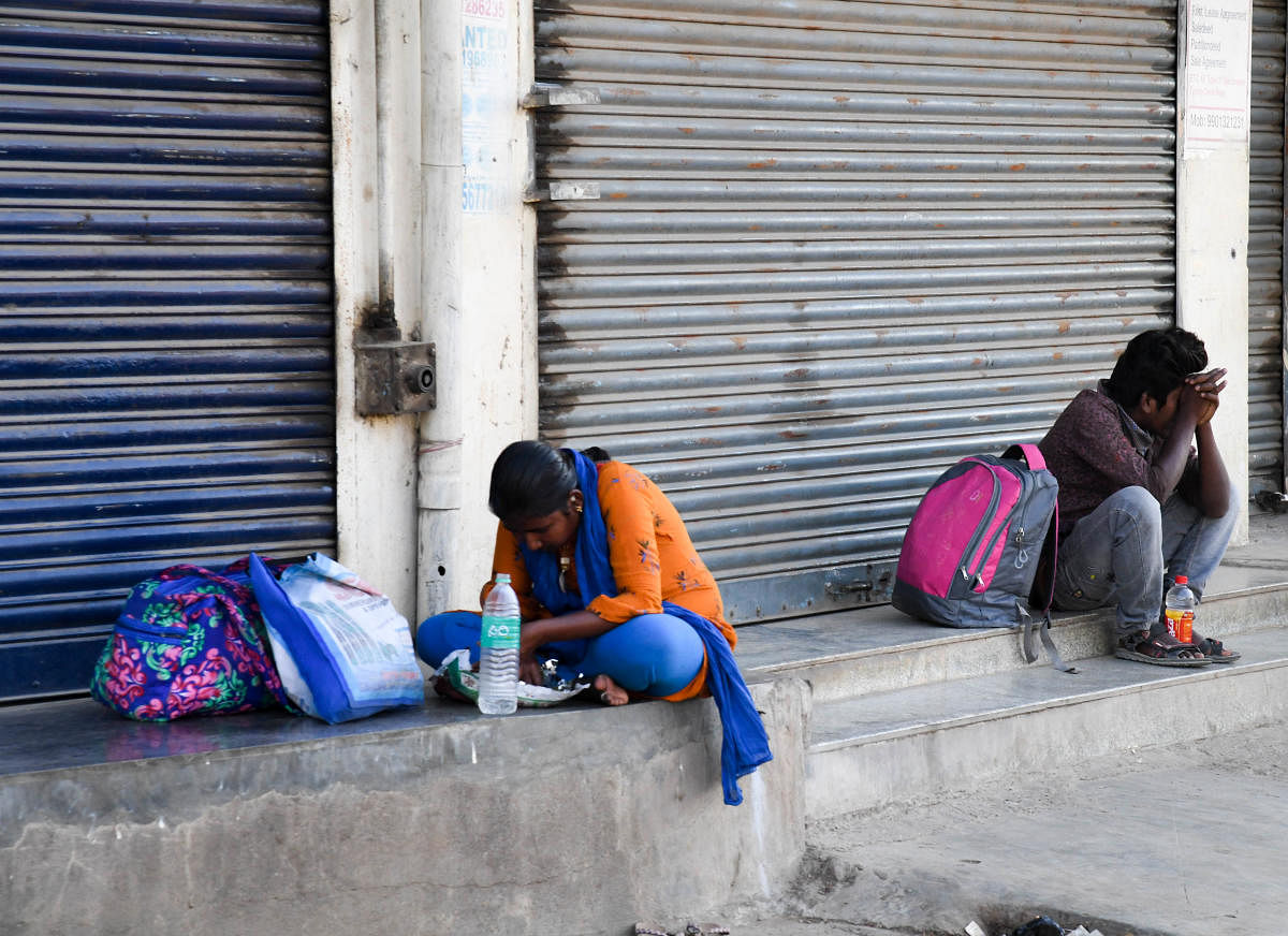A Family taking rest, who walking to reach their place, at Madavara, during a nationwide lockdown, imposed in the wake of coronavirus pandemic, Outskirts of Bengaluru on Tuesday. Photo/ BH Shivakumar
