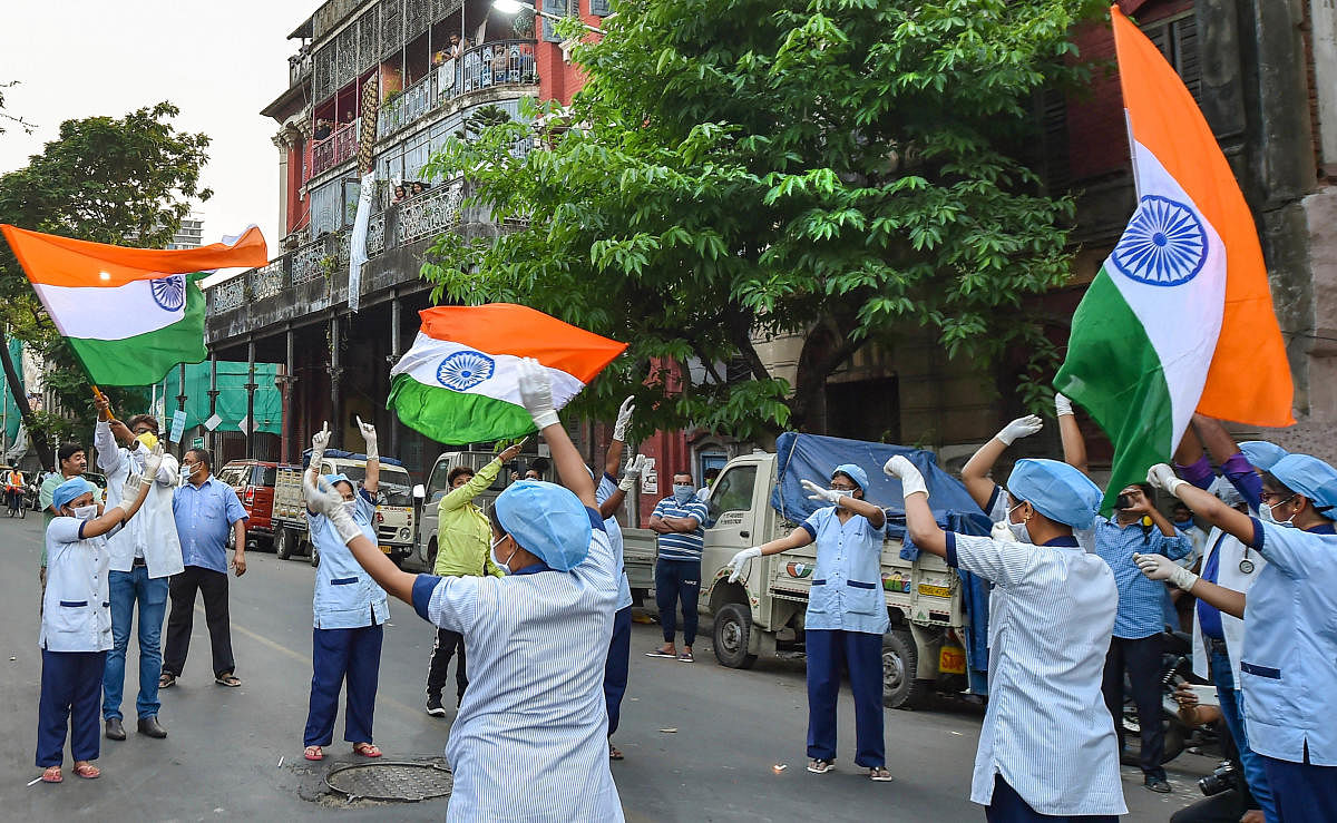 Nurses of JN Ray Hospital hold the Tricolor as a gesture to express their solidarity to mitigate the coronavirus pandemic, during a nationwide lockdown. PTI