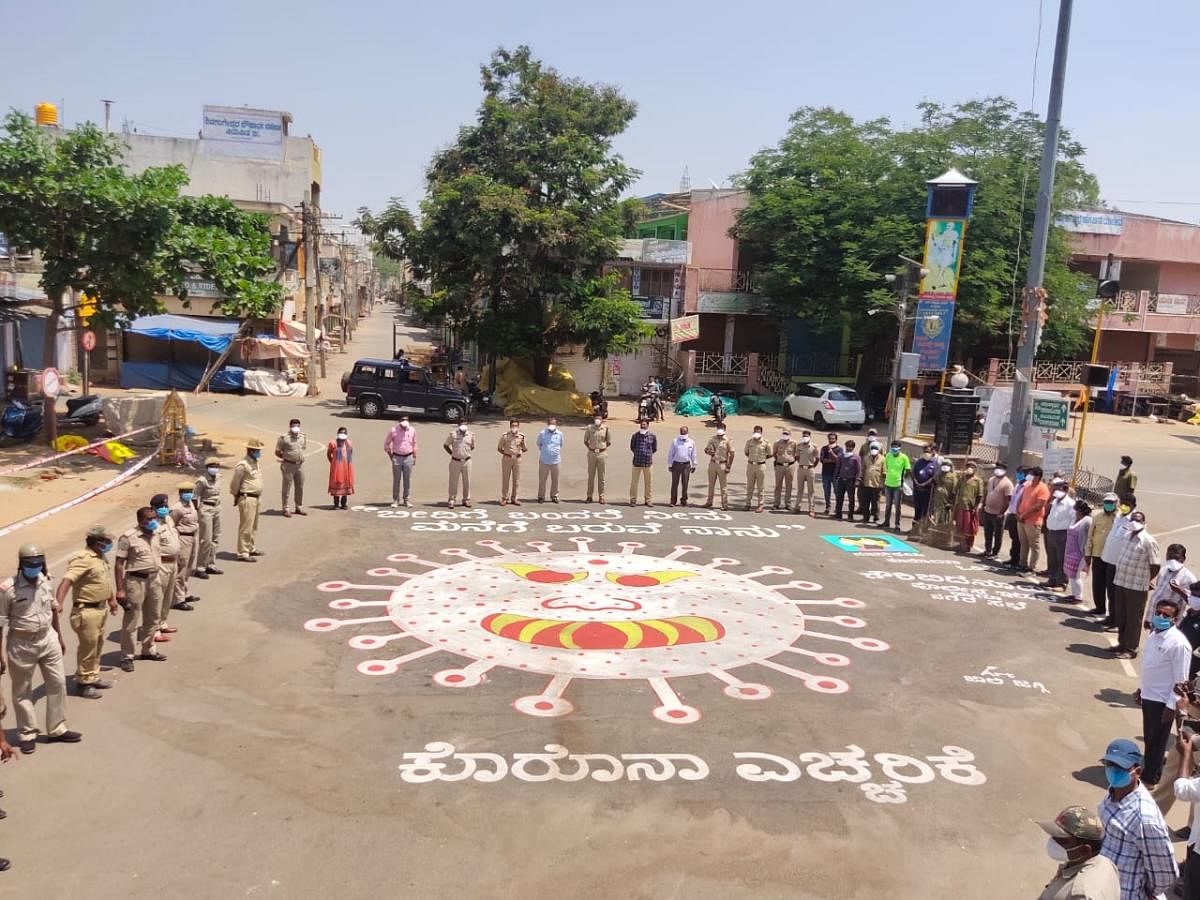 The police form a human chain across novel coronavirus drawing on road to create awareness in Gauribidanur in Chikkaballapur district.