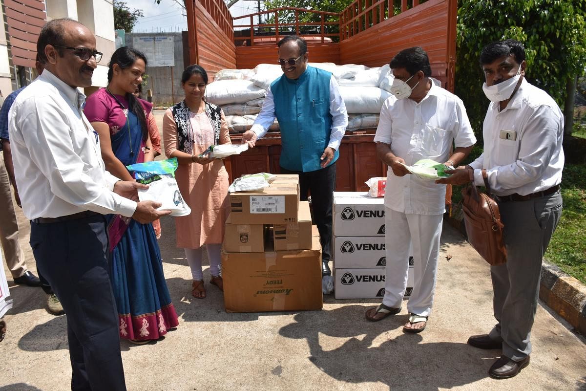 Mobius Foundation Convener Madhu Bopanna hands over the necessary items to the district administration. MLA Appachu Ranjan, Deputy Commissioner Annies Kanmani Joy and SP  Dr Suman D Pannekar look on. DH Photo