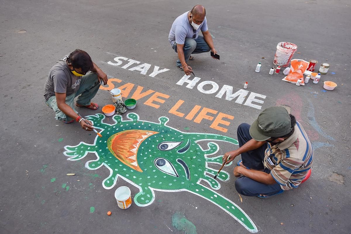 Artists paint graffiti on a road to raise awareness about the COVID-19 during nationwide lockdown imposed to contain the coronavirus pandemic, in Kolkata. (Representative image/PTI Photo)