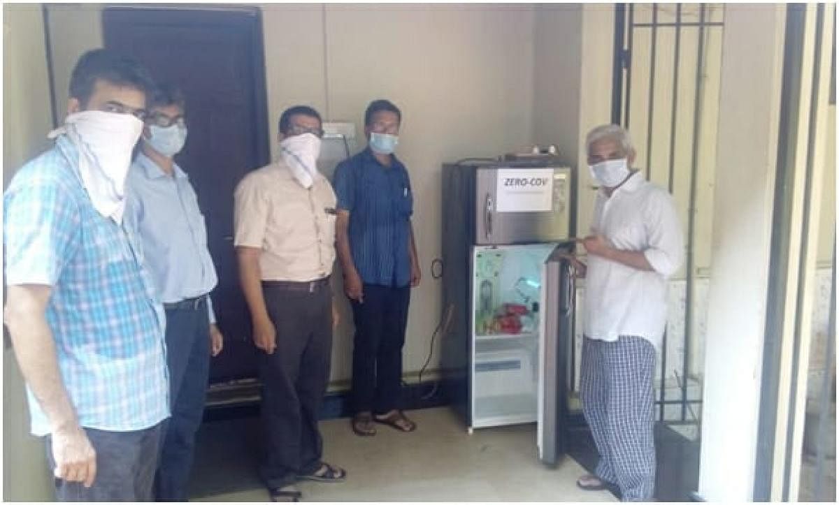 NITK Director Prof K Uma Maheshwar Rao and his wife Neeraja Rao (serving as Headmistress, Kendriya Vidyalaya No 2 in Yekkur) receive an innovative disinfection chamber, `Zero-Cov' from the team of researchers, led by Prof Arun Isloor, at their residence in Mangaluru. 