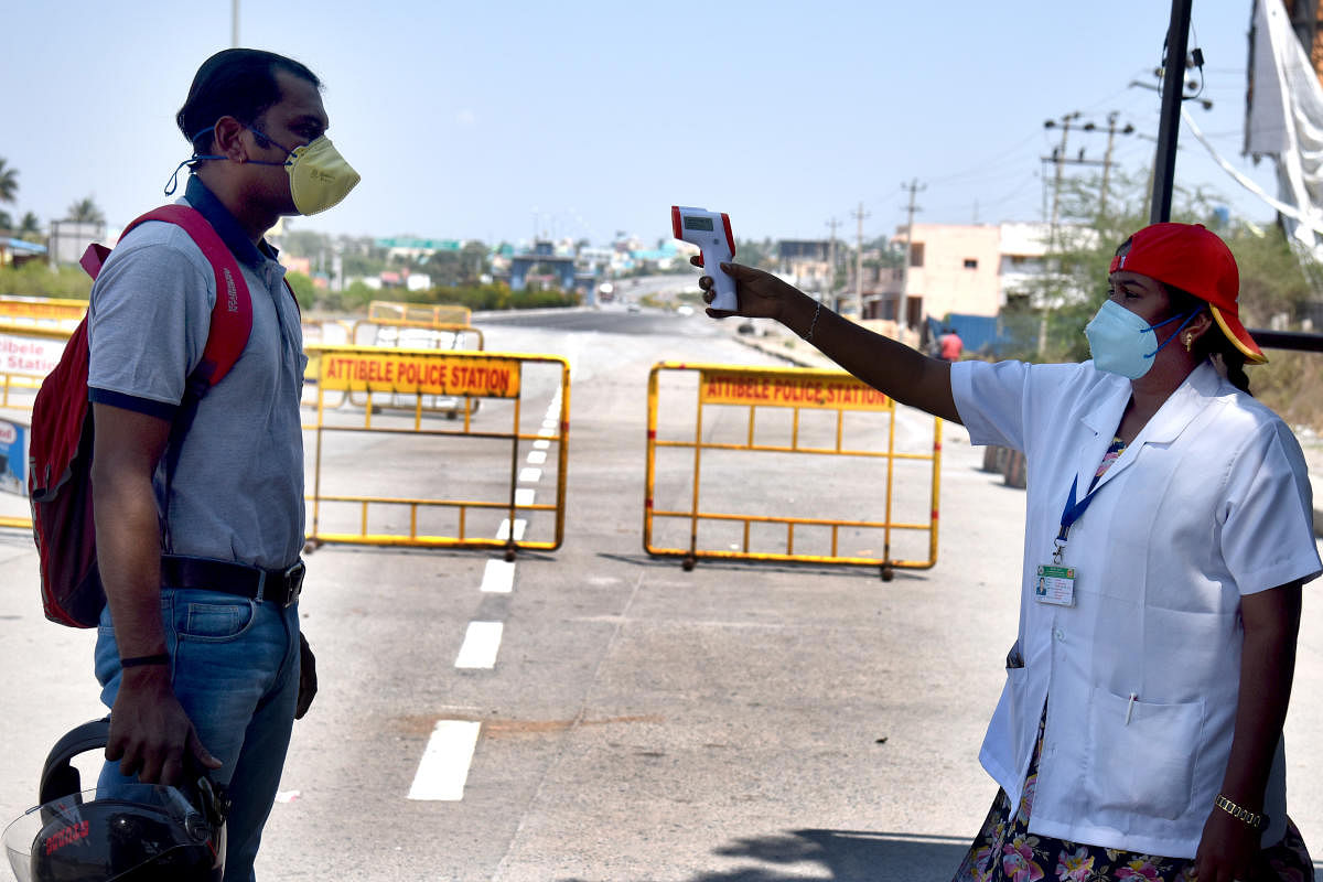 Covid-19 lockdown Medical officer checking body temperature of a person came form Tamil Nadu at Karnataka Tamil Nadu border, Attebele in Bengaluru rural district on Wednesday, 15 April 2020. Photo by S K Dinesh