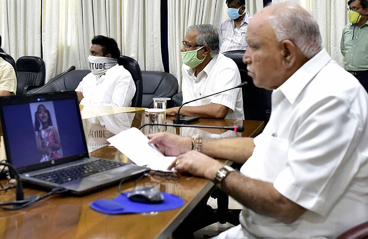 Karnataka Chief Minister B S Yediyurappa (R) with State Education Minister Suresh Kumar (C) inaugurates Youtube Children's Helpline for primary school children, as the nationwide COVID-19 lockdown continues, in Bengaluru, Thursday, Thursday, April 16, 2020. (PTI Photo)