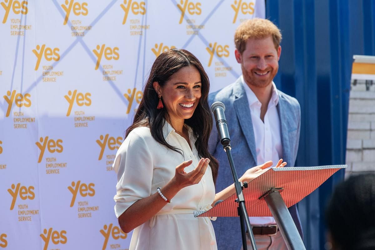 Meghan, Duchess of Sussex (L), is watched by Britain's Prince Harry, Duke of Sussex (R) (AFP Photo)