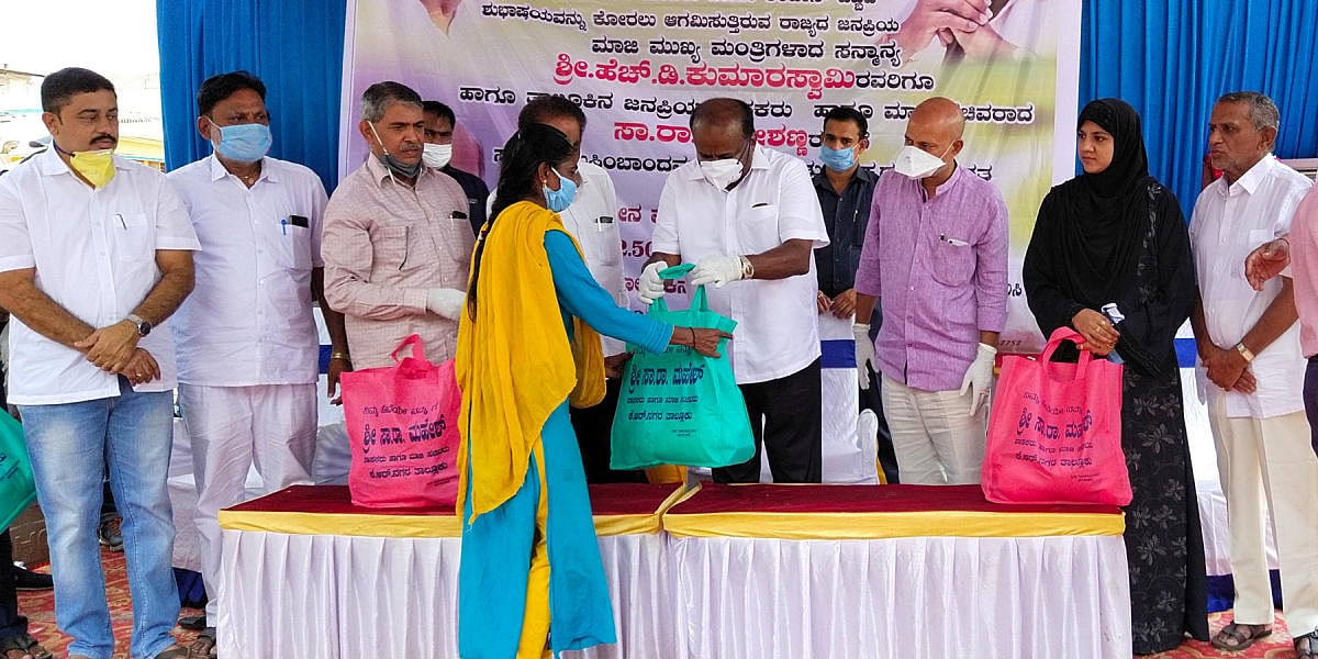 Former chief minister H D Kumaraswamy distribute food kits to the resident of Muslim Layout in K R Nagar, Mysuru district, on Sunday. MLA Sa Ra Mahesh is seen.