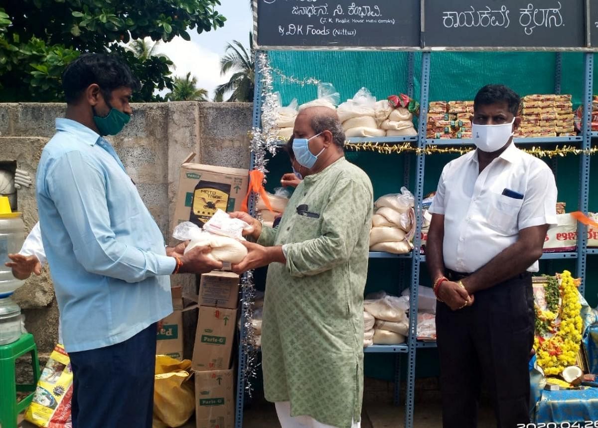 MLA Raghupathi Bhat distributes essential commodities from the wall of humanity in Udupi.