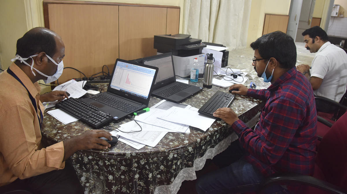 Official busy collating data at Covid-19 State War Room housed in Balabrooie Guesthouse, Bengaluru. DH File Photo