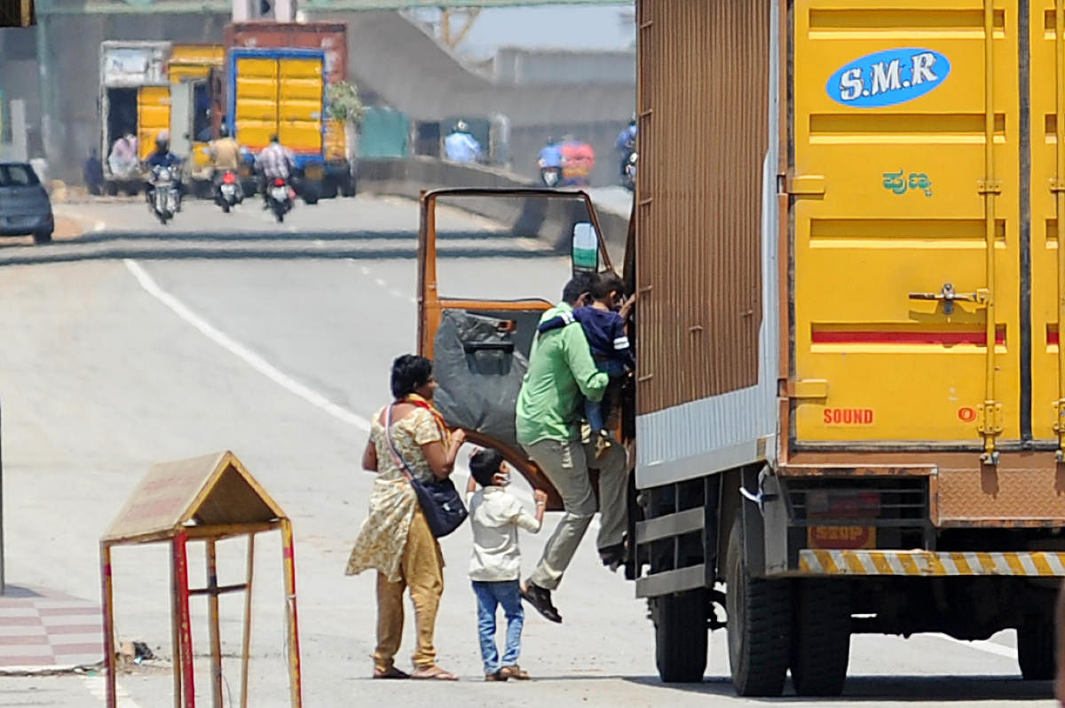 A family hitches a ride on a truck on Tumakuru Road in Bengaluru on Thursday. DH Photo/Pushkar V
