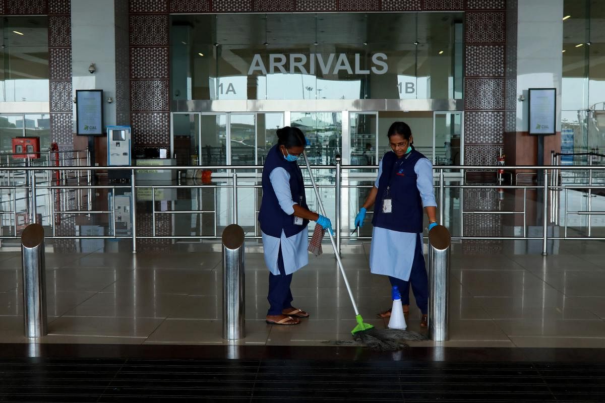 Airport staff cleans the arrivals terminal ahead of the arrival of an evacuation flight carrying Indian citizens from Gulf countries, at the Cochin International Airport in Kochi on May 6, 2020. (Photo by AFP)