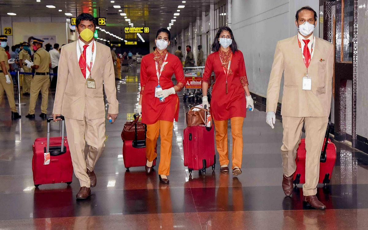 Cabin crew of an Air India Express flight, which evacuated Indian nationals stranded in Bahrain following suspension of commercial air passenger services due to coronavirus pandemic, at Calicut International Airport in Kozhikode, Monday, May 11, 2020. (PTI Photo)