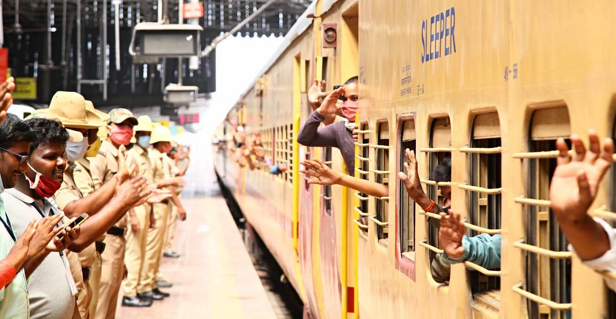 A migrant worker aboard Shramik Special salutes police officers as the train chugs off from the railway station in Ballari on Sunday.