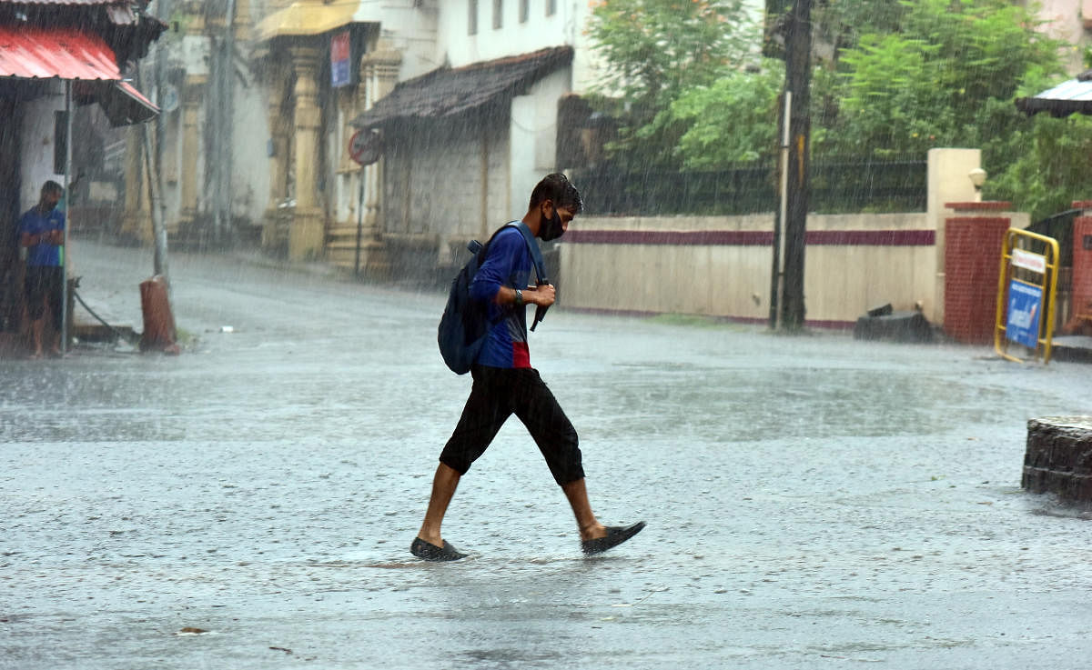 A boy is drenched to the skin after he was caught unawares by the sudden downpour that lashed Mangaluru and surrounding areas on Monday morning.
