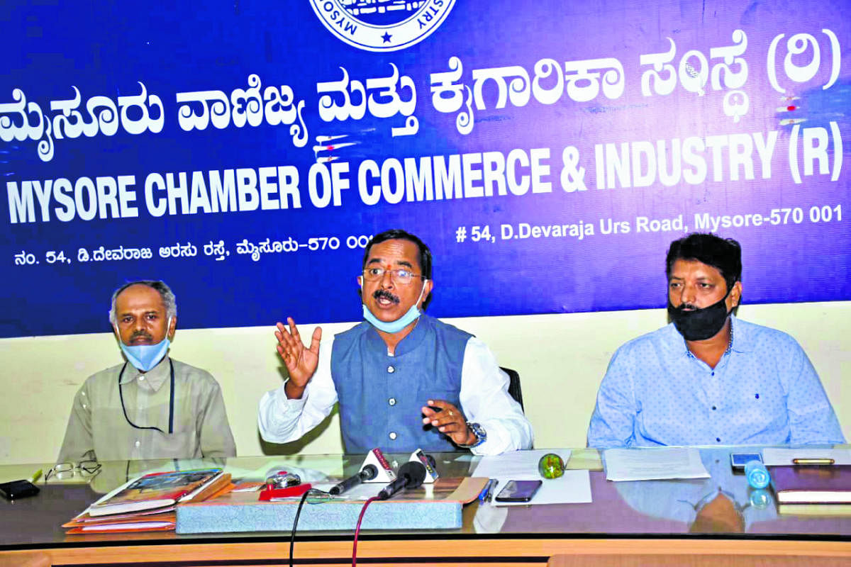 Federation of Chamber of Commerce and Industries ex-president Sudhakar S Shetty addresses media persons in Mysuru on Monday. MCCI president A S Satish and Hotel Owners’ Association president C Narayana Gowda are seen.