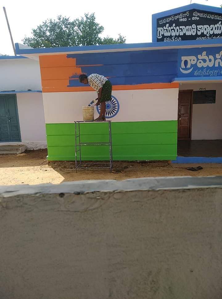 A painter replacing national flag with YSRC party colours in Tamidepalli. DH photo
