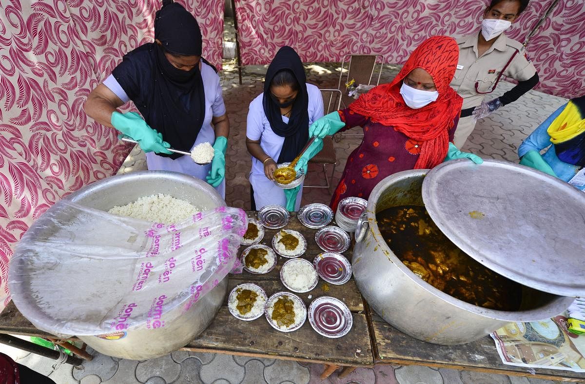 Volunteers distribute food among the needy during a nationwide lockdown in the wake of coronavirus outbreak, at a relief camp in New Delhi, Friday, April 3, 2020. (PTI Photo)