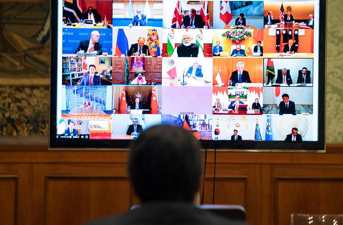 This photo taken and handout by the press office of Palazzo Chigi on March 26, 2020 shows Italian Prime Minister, Giuseppe Conte (L) taking part in a video conference as part of an extraordinary meeting of G20 leaders, from the Chigi Palace in Rome, during the country's lockdown following the COVID-19 new coronavirus pandemic. Credit: AFP Photo