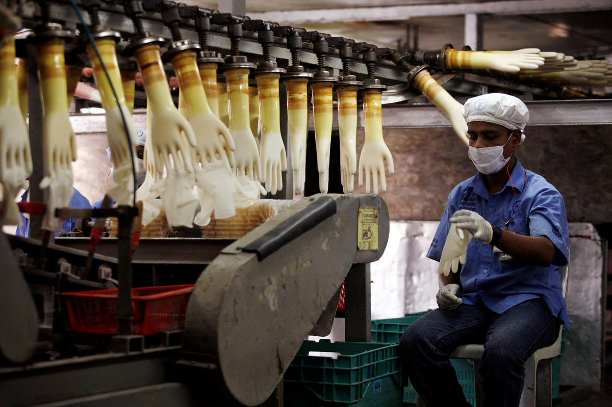 A worker monitors a production line at a Top Glove factory (Reuters Photo)