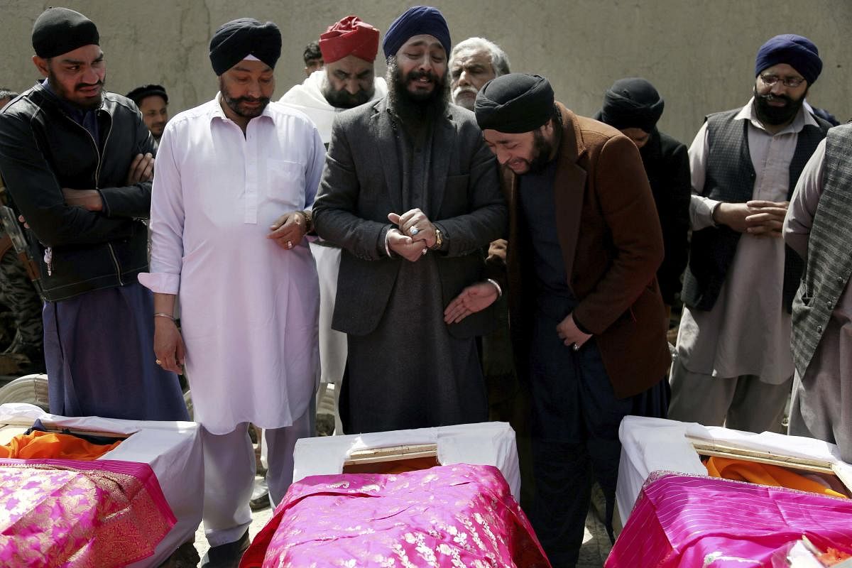 Afghan Sikh men mourn their beloved ones during a funeral procession for those who were killed in Gurudwara attack (AP Photo)