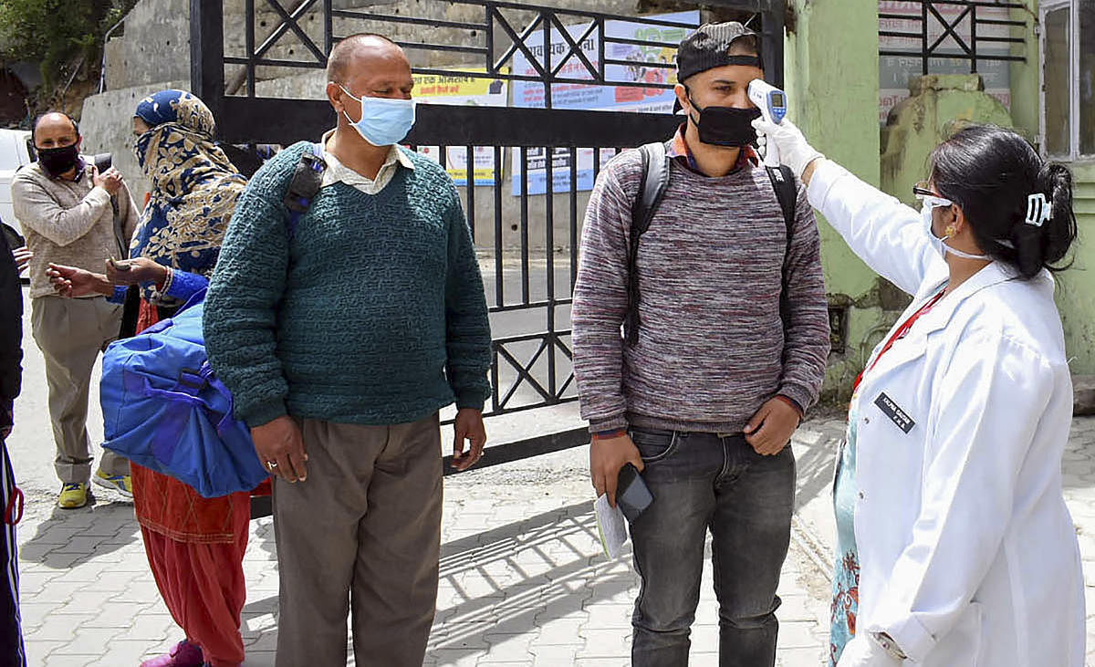 Health worker check temperature of visitors at IGMC Hospital after administration opened its OPD during the nationwide lockdown, imposed to curb the coronavirus pandemic, Shimla, Thursday, April 16, 2020. (PTI Photo)