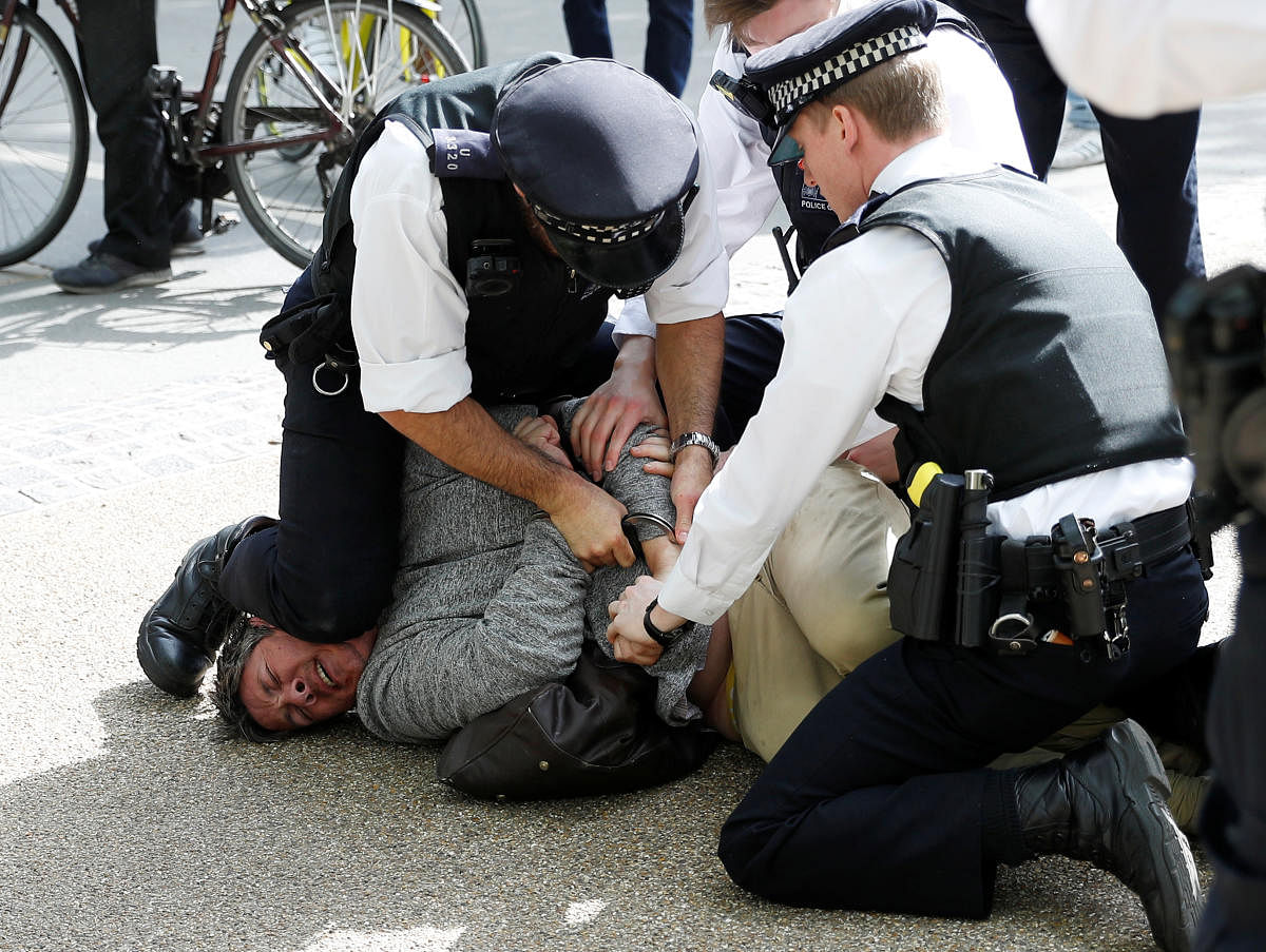 A protester is detained by police officers during a demonstration in Hyde Park. Reuters