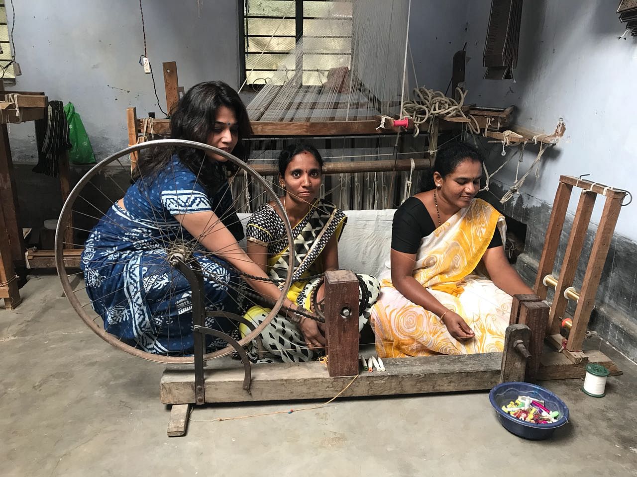A visitor tries her hand at making yarn at Kodiyala in Mandya district.