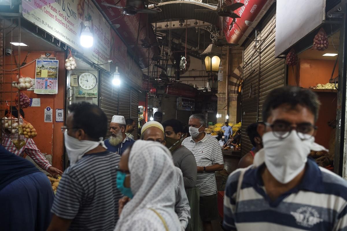 People, some wearing facemasks as a preventive measure against the COVID-19 coronavirus, shop in a local market during a government-imposed lockdown in Mumbai on March 24, 2020. Credit: AFP Photo