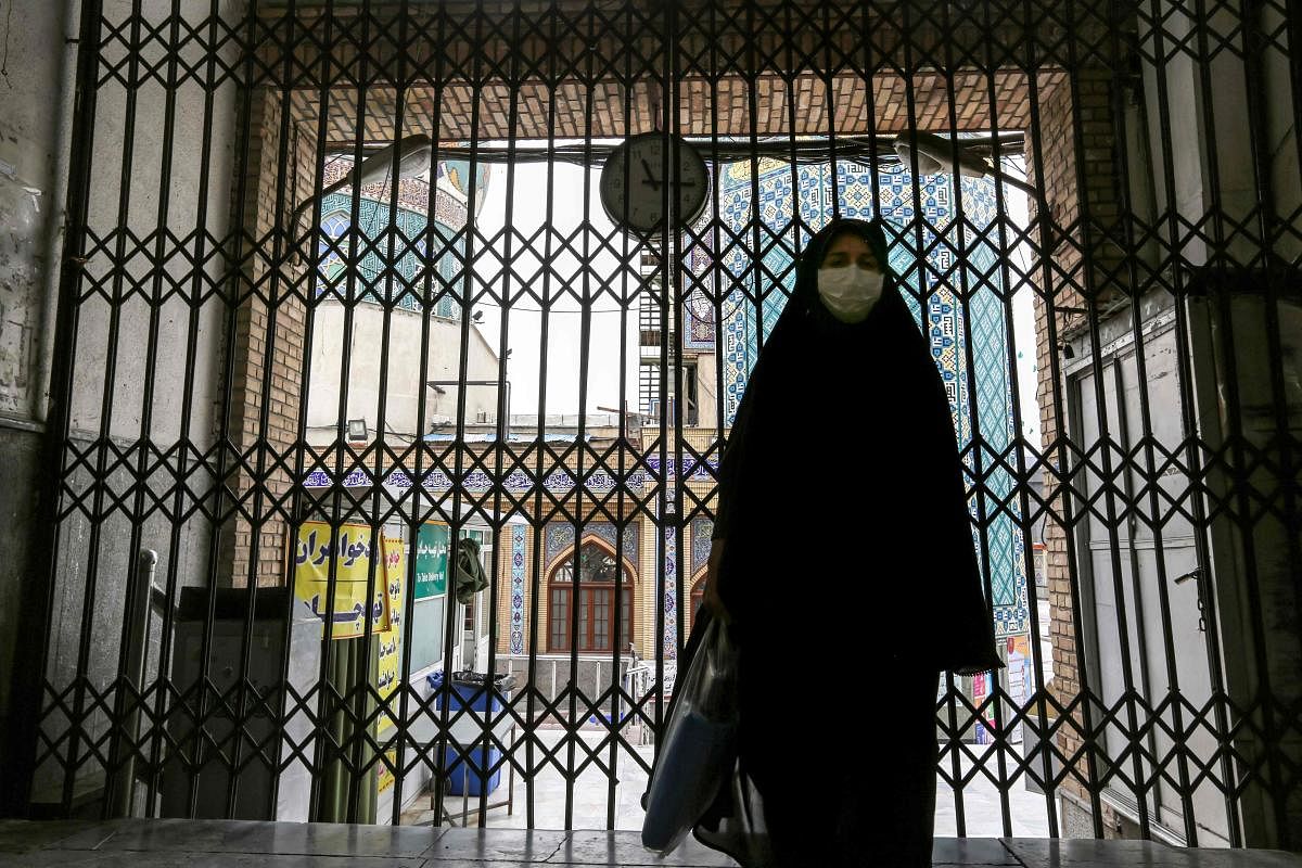 A woman walks past the closed gate outside the Imamzadeh Saleh in the Iranian capital Tehran's Shemiran district on April 25, 2020 during the Muslim holy month of Ramadan, as all mosques and places of worship are closed due to the COVID-19 coronavirus pandemic. Credit: AFP Photo