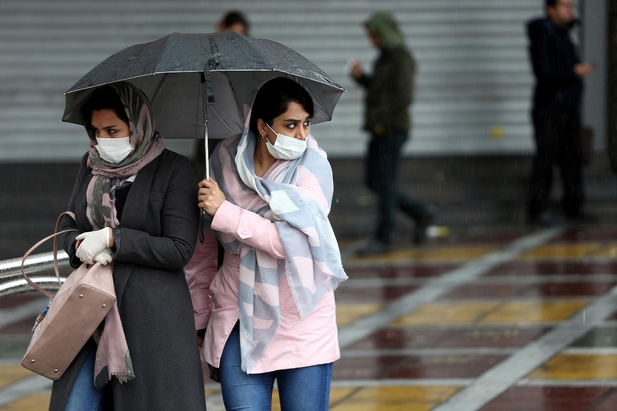  Iranian women wear protective masks to prevent contracting coronavirus, as they walk in the street in Tehran. Credit: Reuters Photo