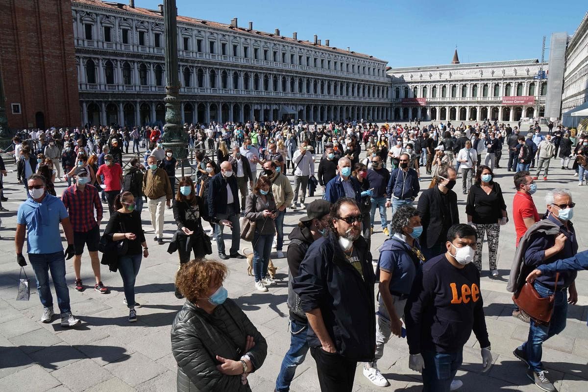 Storekeepers asking for the reopening of shops and commercial activities gather for a flashmob protest on Piazza San Marco on May 4, 2020 in Venice, as Italy starts to ease its lockdown, during the country's lockdown aimed at curbing the spread of the COVID-19 infection, caused by the novel coronavirus. Credit: AFP Photo