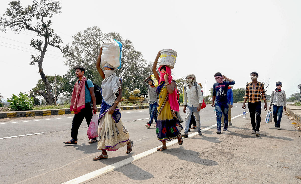 Migrant workers along with their family members walk to their villages amid the nationwide complete lockdown, in wake of coronavirus pandemic, at NH12 in Jabalpur, Friday, March 27, 2020. (PTI Photo)