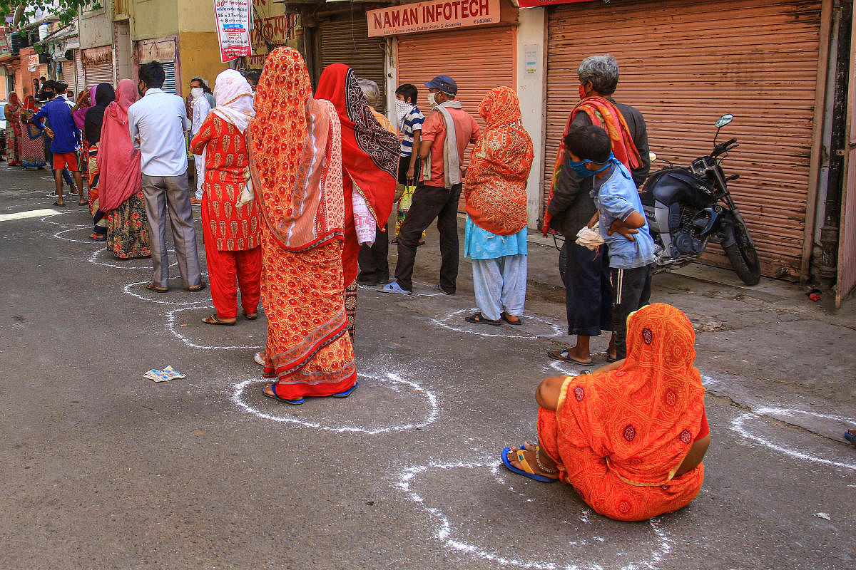People respecting social distancing guidelines wait in queues to receive food during COVID-19 lockdown in Jaipur, Sunday, April 26, 2020. (PTI Photo)