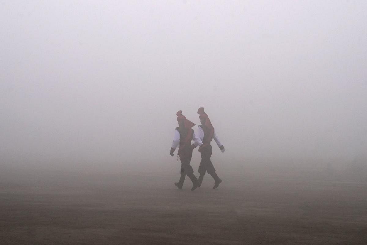 Indian army soldiers from the Jammu and Kashmir Light Infantry (JAKLI) walk on a dense fog before a passing out parade at JAKLI army headquarter. AFP