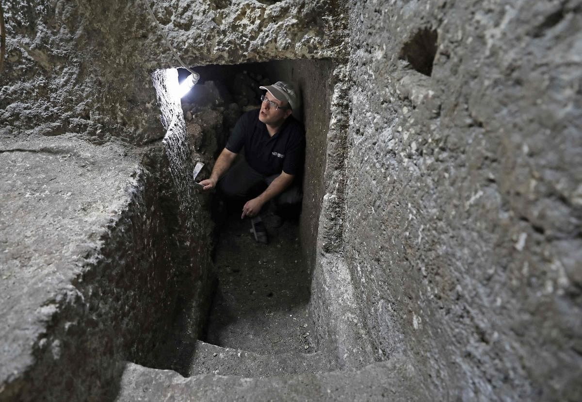 Barak Monnickendam-Givon, an archaeologist of the Israel Antiquities Authority, works at an excavation at a subterranean system hewn in the bedrock beneath a 1400-year-old building near the Western Wall in Jerusalem's Old City. AFP