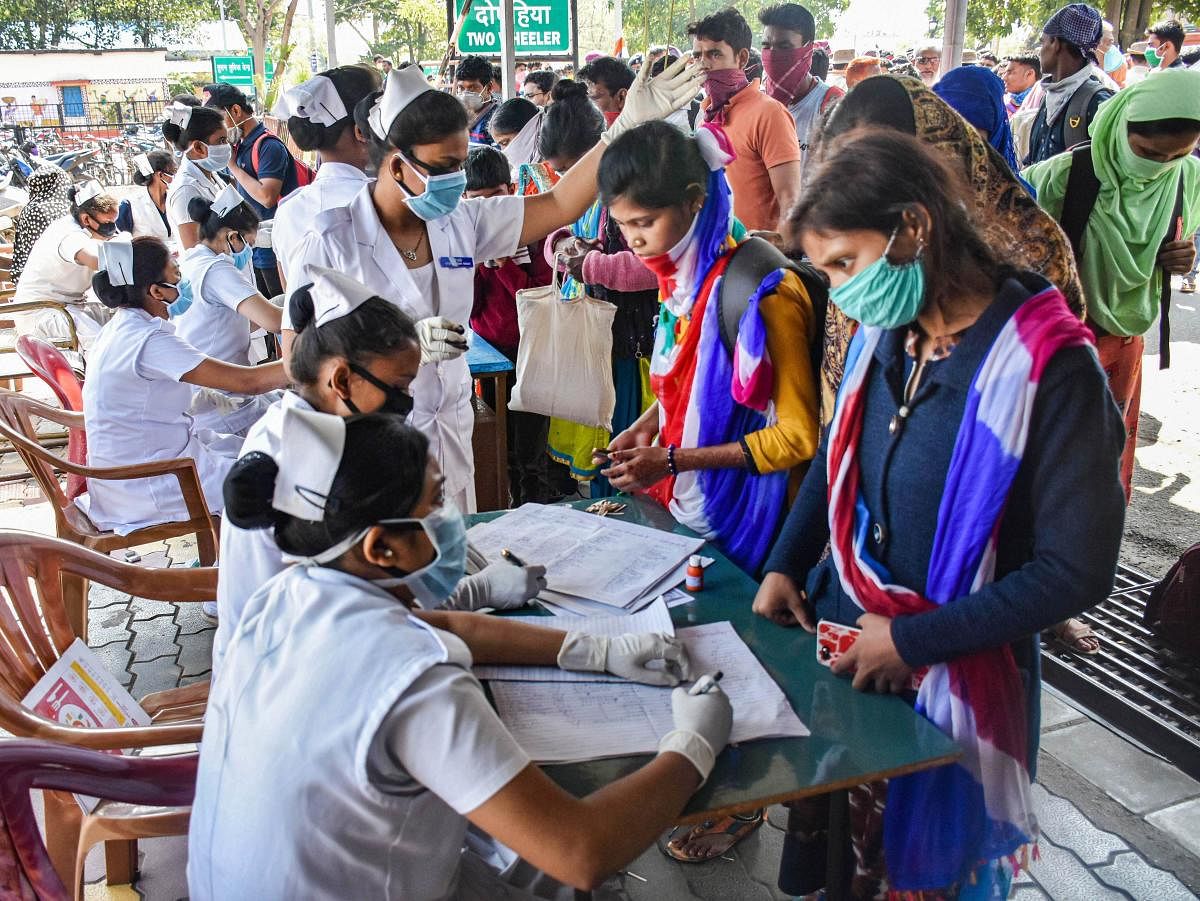 Passengers wait in a queue to get screened at Hatia Railway Station in view of coronavirus pandemic, in Ranchi, Monday, March 23, 2020. (PTI Photo)