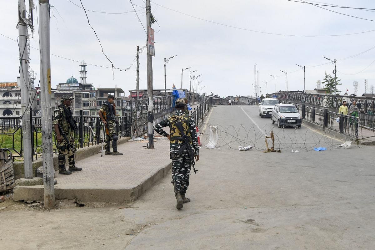 Security personnel stand guard during restrictions in Srinagar. AFP